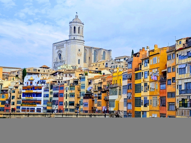 Colorful riverside buildings with a church in the background.