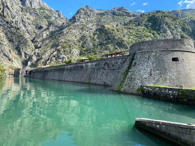 Stone fort beside a calm turquoise river.