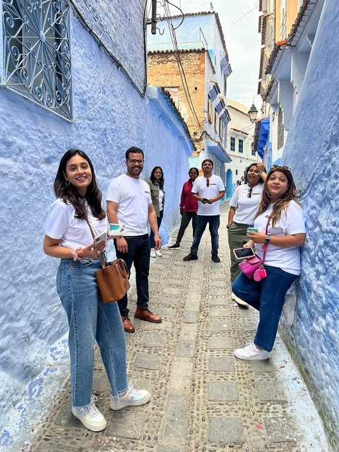 Group of people standing in a blue-washed alley.