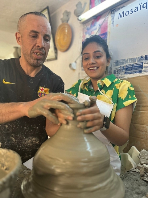 People crafting pottery with clay.
