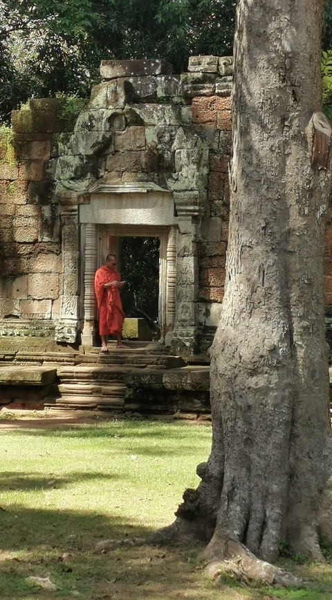 Monk standing at an ancient Cambodian temple.