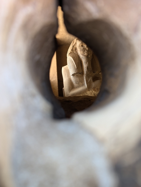 Blurry view through a keyhole of a statue.