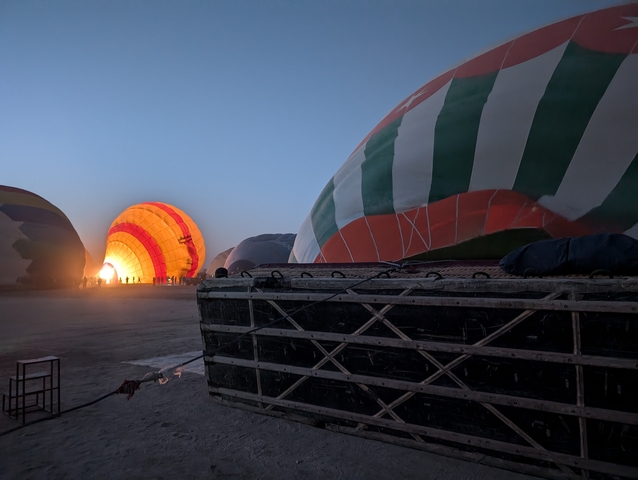 Hot air balloons being inflated at dusk.