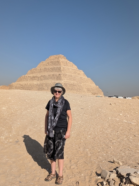 Woman posing in front of a pyramid.