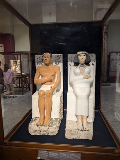 Two ancient statues in a museum.