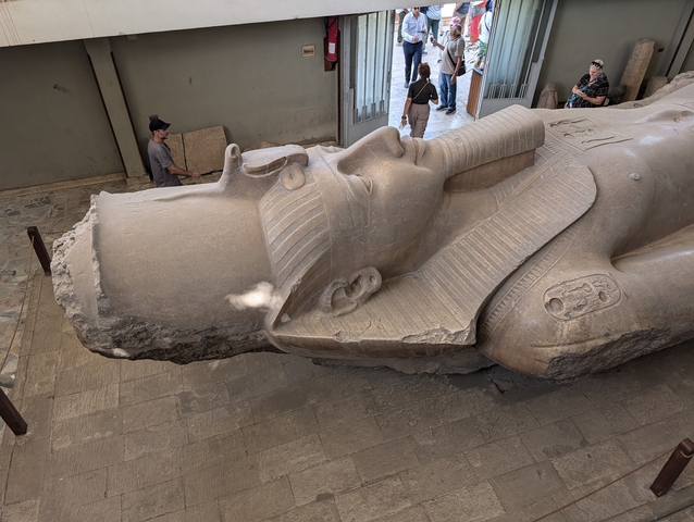 Large statue lying on its side in a museum.