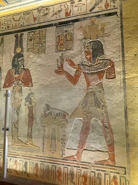 Ancient Egyptian wall carving with detailed figures.