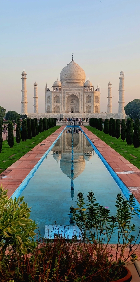 Reflection of the Taj Mahal in a long fountain pool.