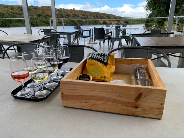 Glasses of wine on a table overlooking a water body.