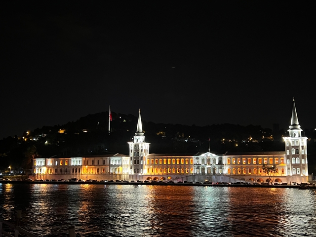 Night view of a lit-up historical building by the water.