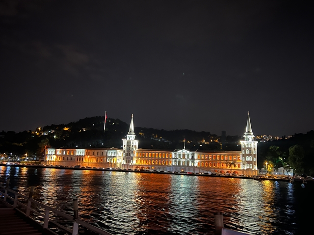 Night view of a prominently illuminated building by the water.