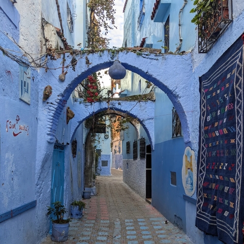 Narrow alleyway in a blue-painted medina.