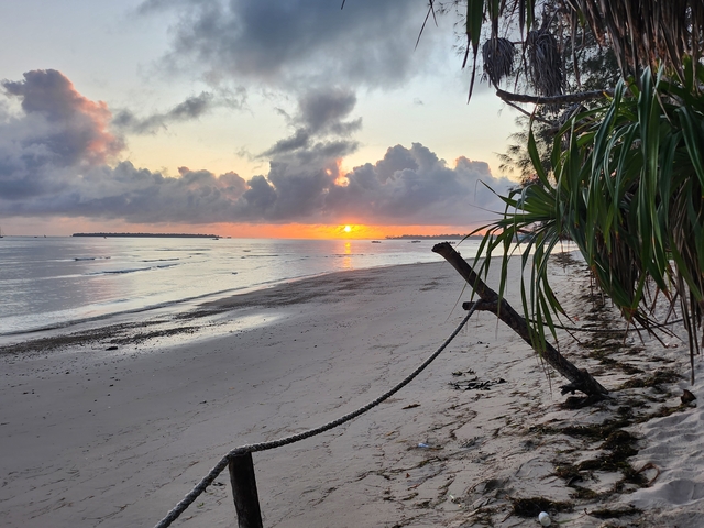 Sunset on a beach with dramatic clouds.