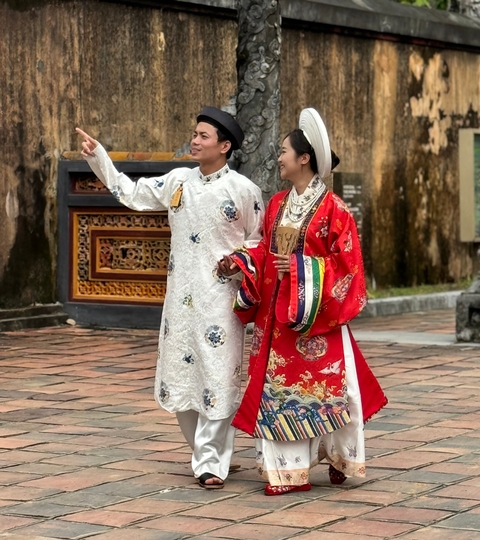 Man and woman in traditional attire taking a selfie