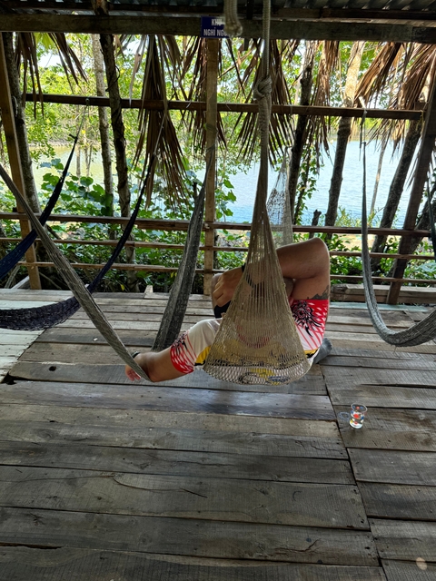 Person relaxing in a hammock near the water