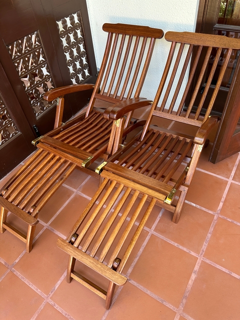 Wooden reclining chairs on a tiled floor.