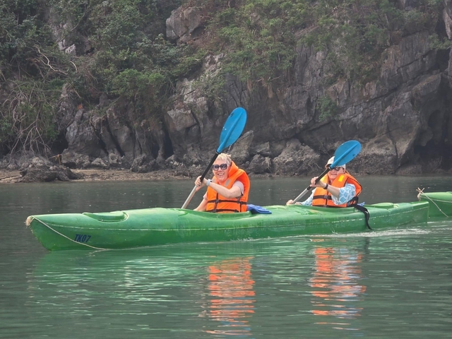 Two people kayaking in tranquil waters.
