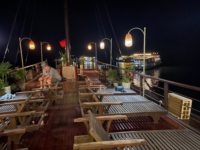 People relaxing on a boat deck at night.