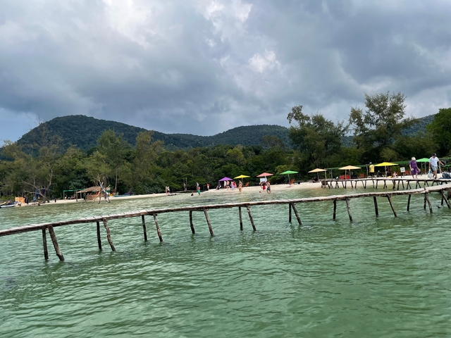 Beach with colorful umbrellas and people.