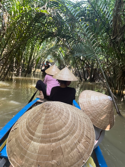 People in traditional boats navigating through mangroves.