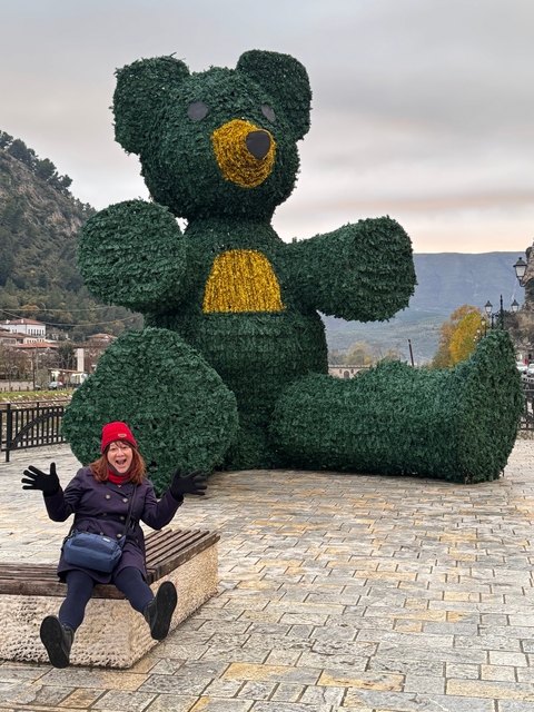 Person posing with a decorated bush sculpture.