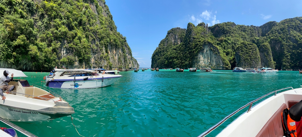 Limestone cliffs and boats on a turquoise sea.