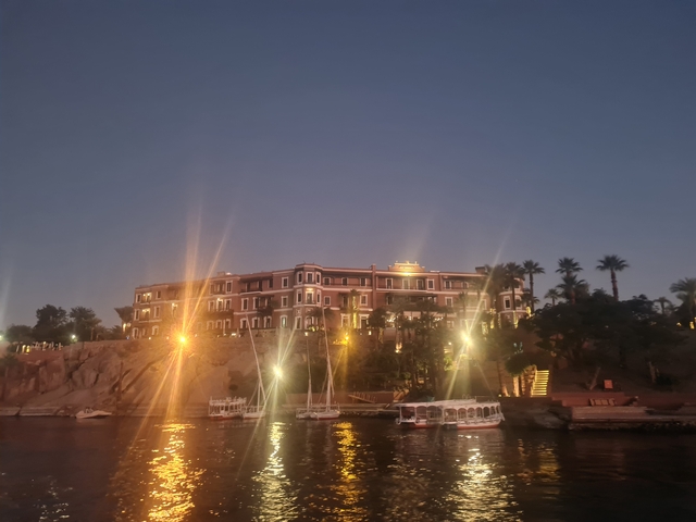 A lit-up riverside hotel at night.