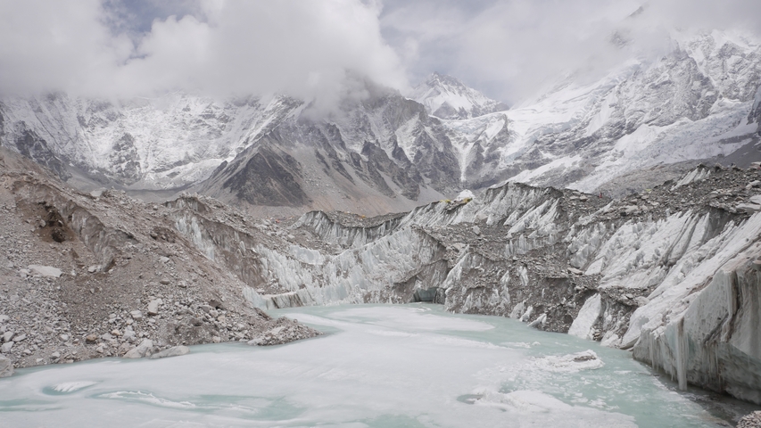 Icy lake surrounded by snow-covered mountains.