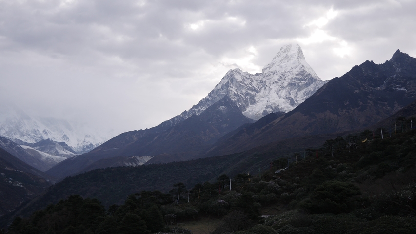 Snow-covered mountain peaks under a cloudy sky.