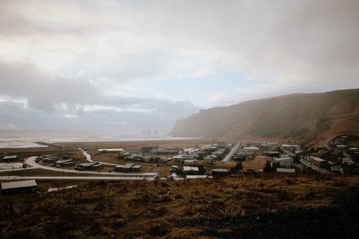 Aerial view of a coastal town surrounded by mountains and cliffs.
