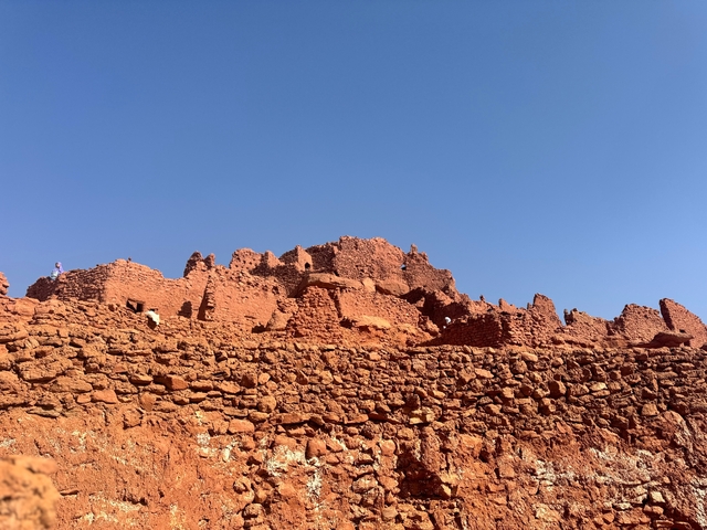 Old ruins made of red bricks set against a blue sky.