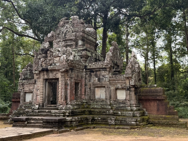 Ancient temple ruin amidst lush greenery.