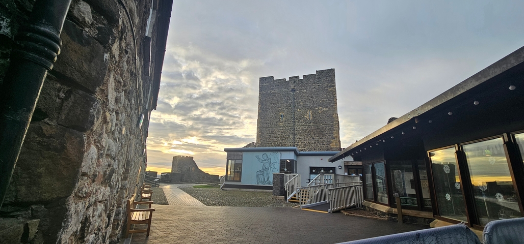 Stone castle with surrounding walkway and art mural.