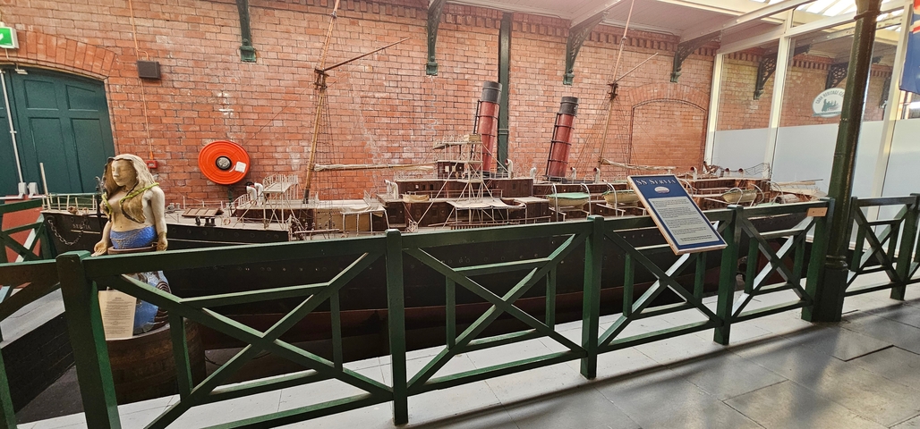 Inside a museum with a large ship model on display.