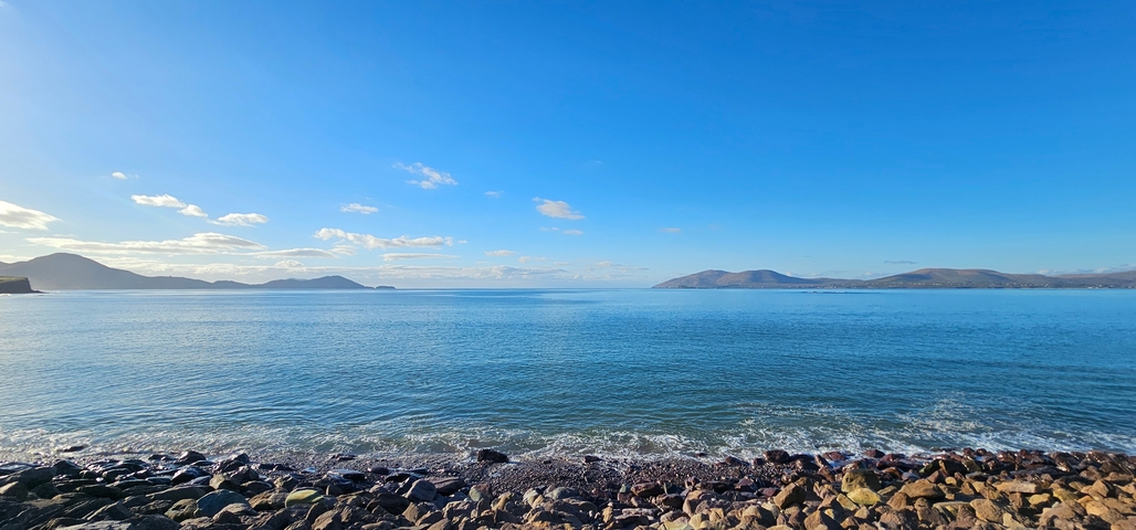 Coastal view with distant mountains under a clear sky.