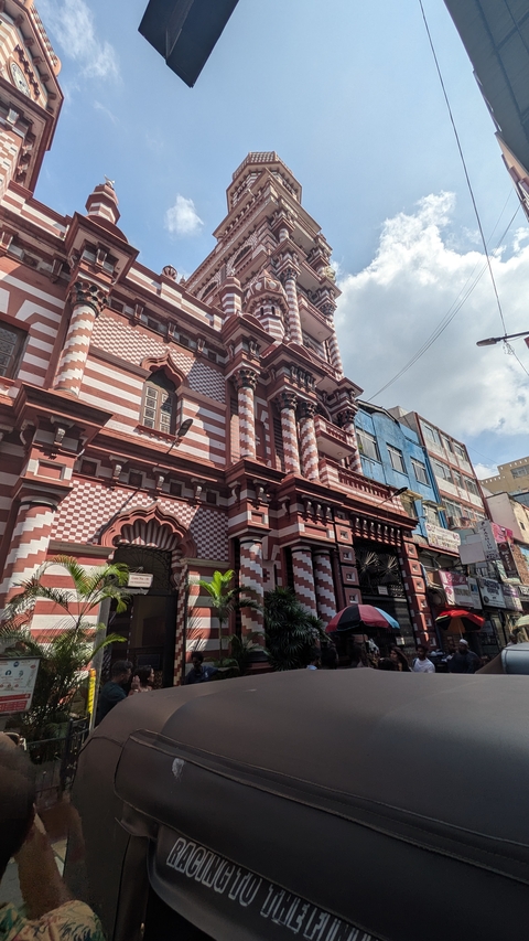 Red and white striped mosque with intricate architecture.