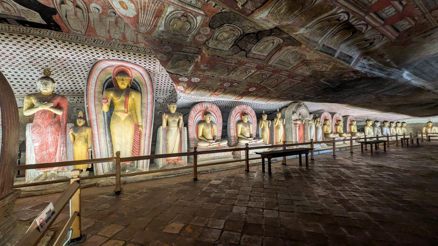 Wall of a cave temple with numerous Buddha statues.