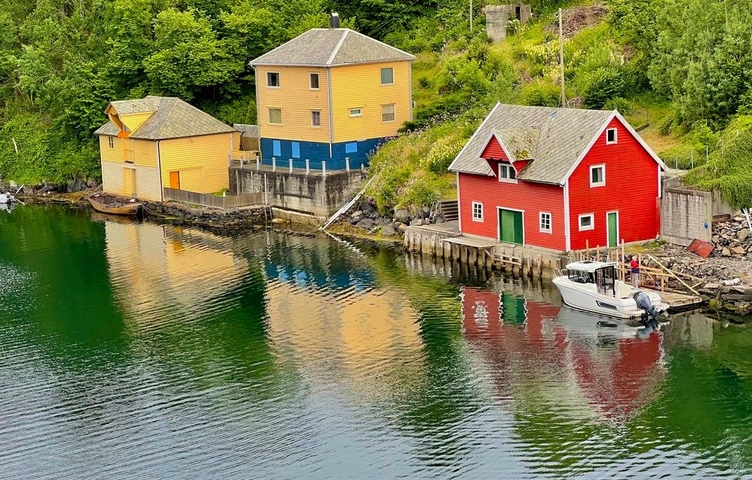 Colorful wooden houses reflecting on the water's surface.