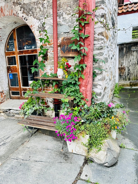 Flowers decorating a quaint corner with rustic brick and wood.
