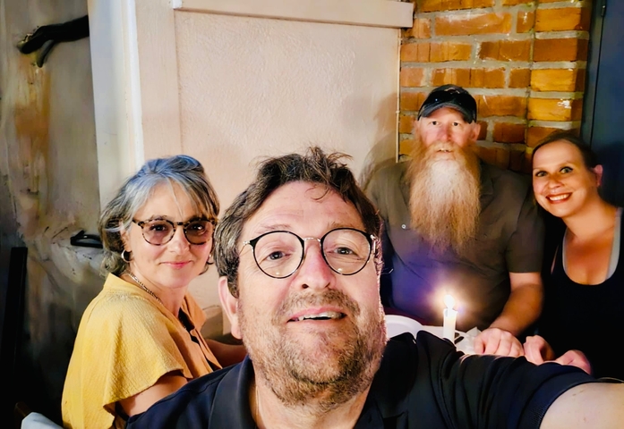 Group of friends dining at a candle-lit table.