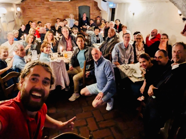 Large group of people eating at a crowded restaurant.
