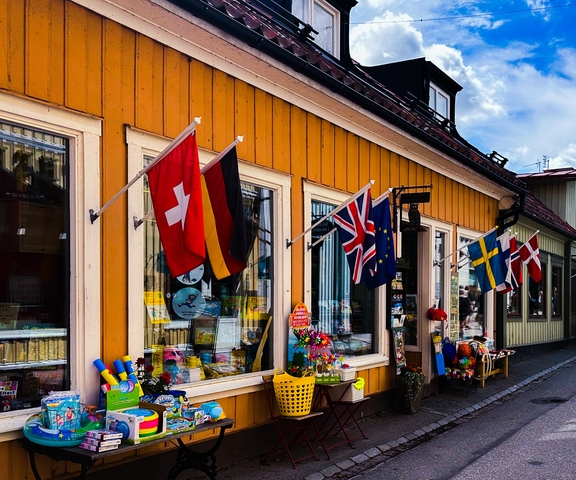 Street scene with colorful flags and shops.