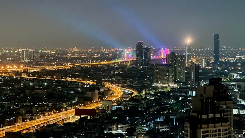 Nighttime cityscape with illuminated bridges and skyscrapers.