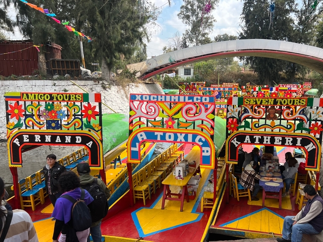 Colorful traditional boats with elaborated signage and people inside.
