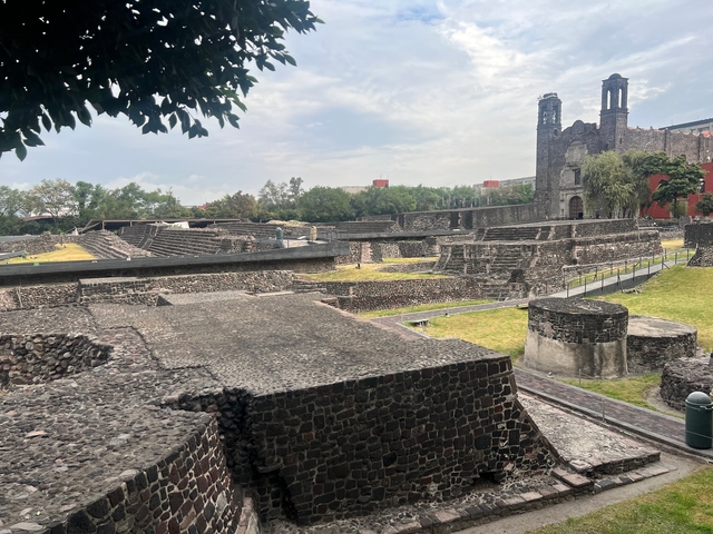 Ruins of an ancient structure with brick walls and grassy areas.