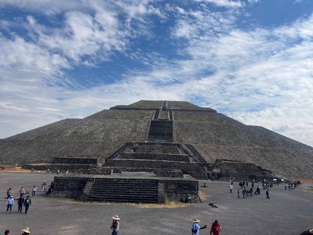 An ancient pyramid structure with people around.