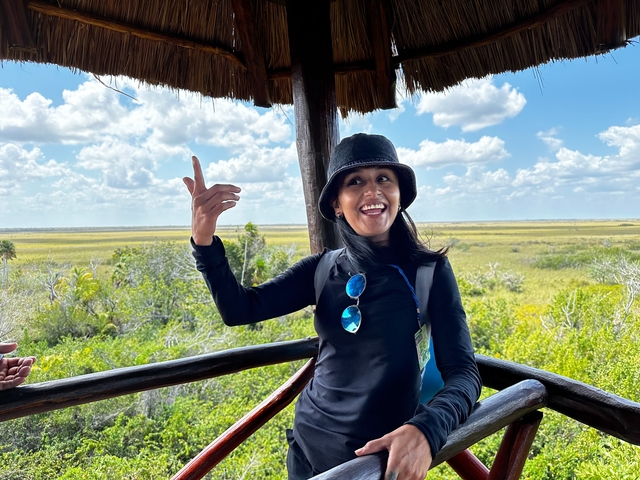 Woman on a viewing platform with wetlands behind.