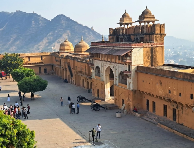 Large group of people at a historical fort with cannons.
