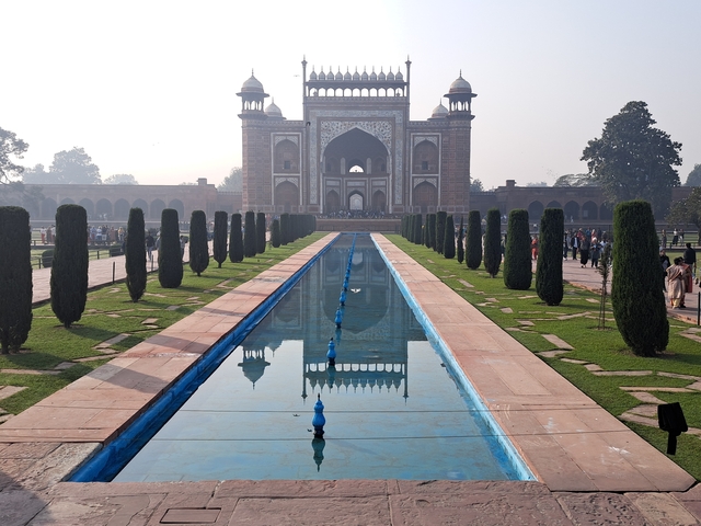 Large historical gate with a reflective water pool.