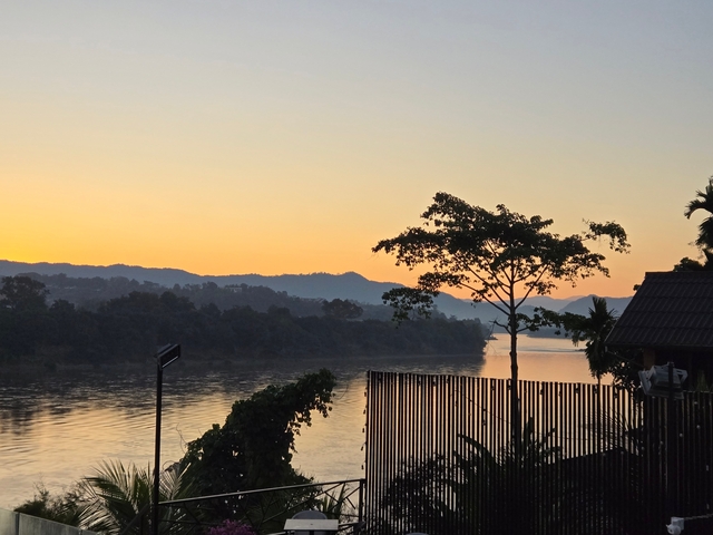 A calm river during sunset with mountains in the background.